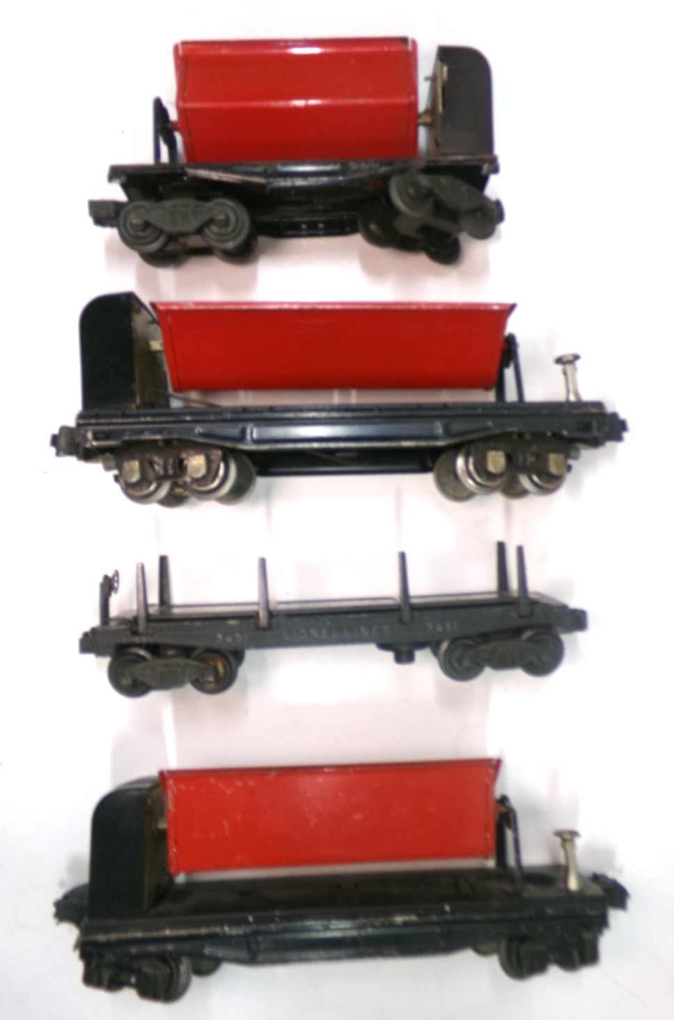 (3) O gauge Lionel dump cars + (1) log car (lot 7162)