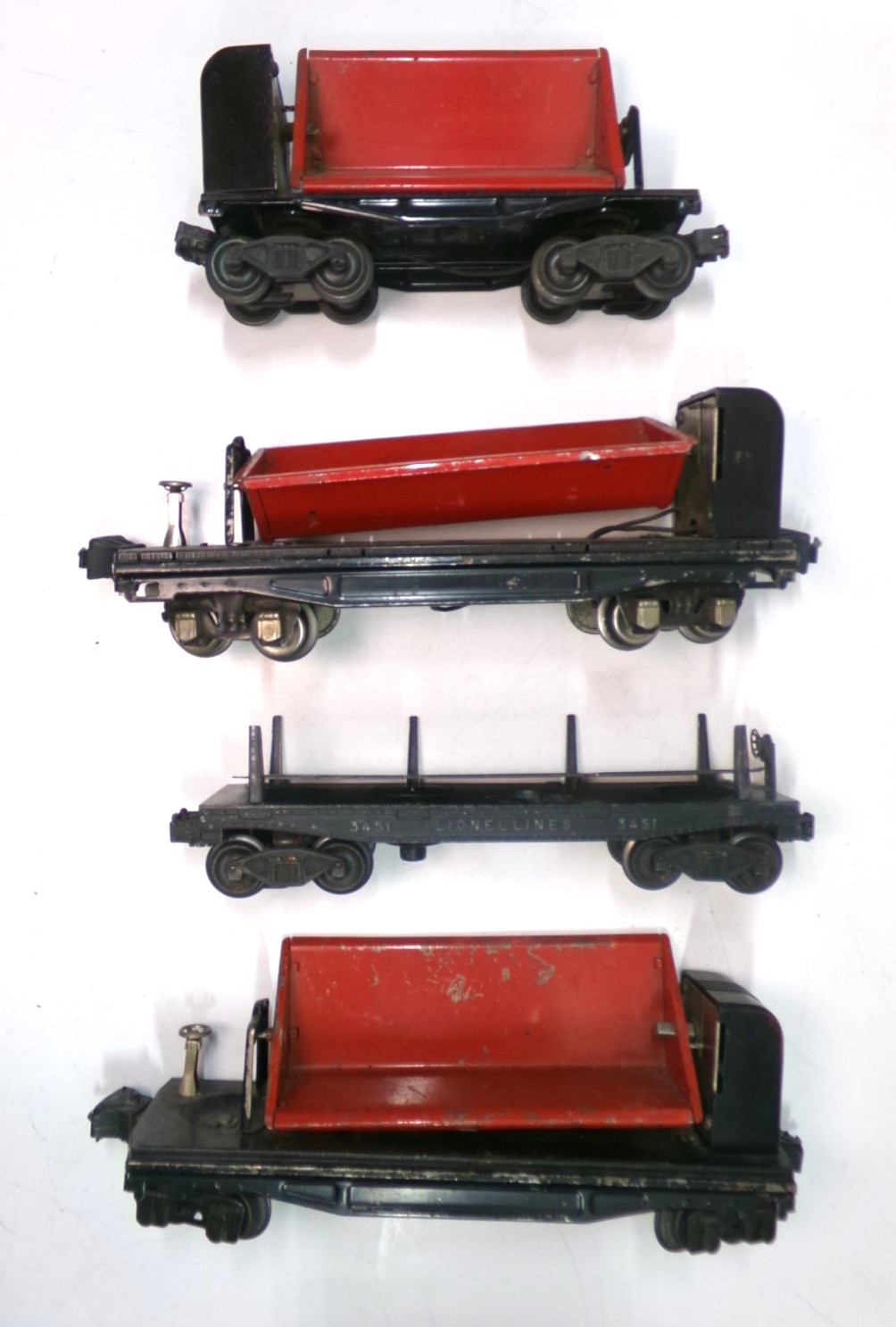 (3) O gauge Lionel dump cars + (1) log car (lot 7162)