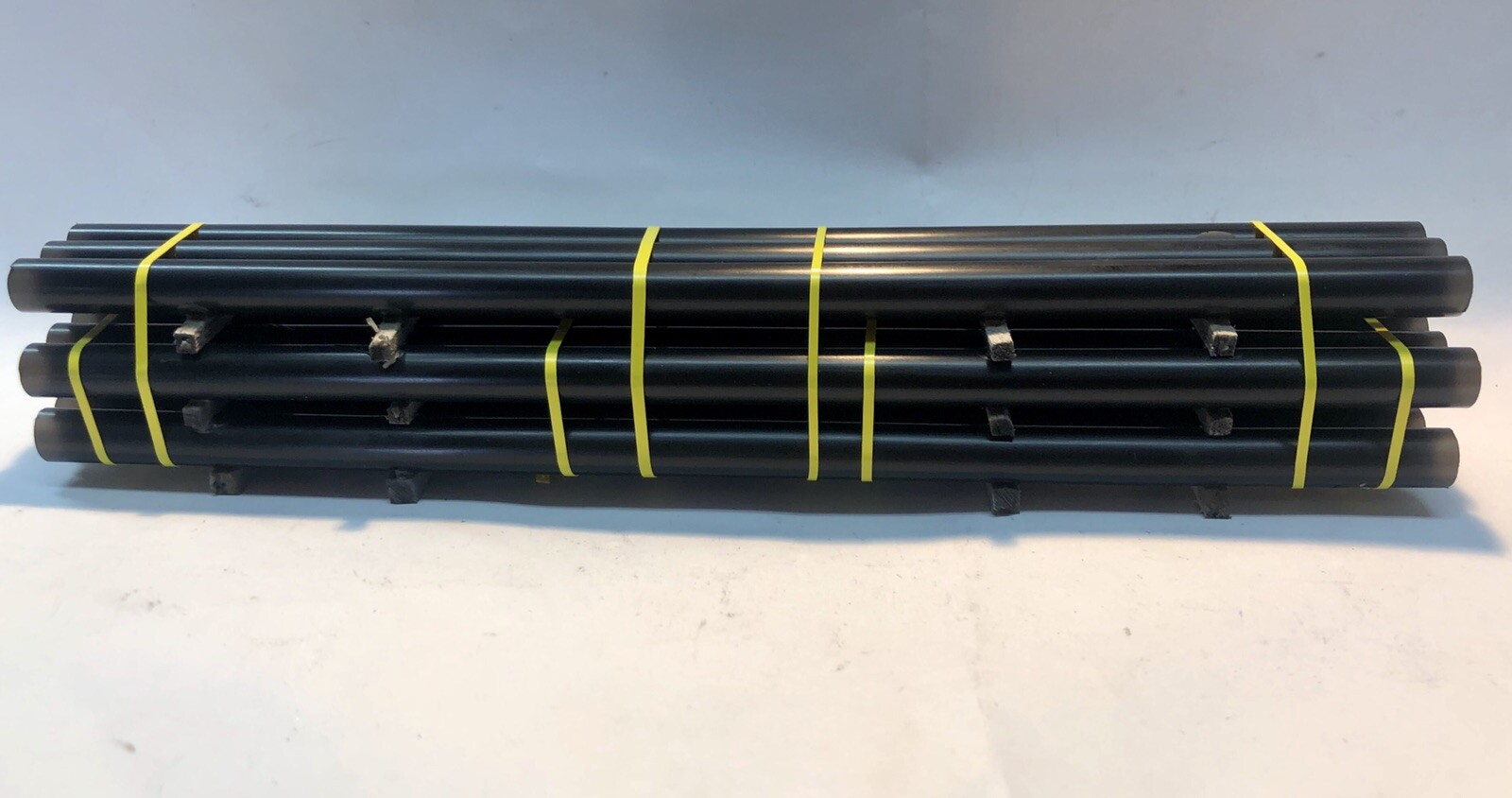 HO Scale 50′ Flatcar Pipe Load. Black